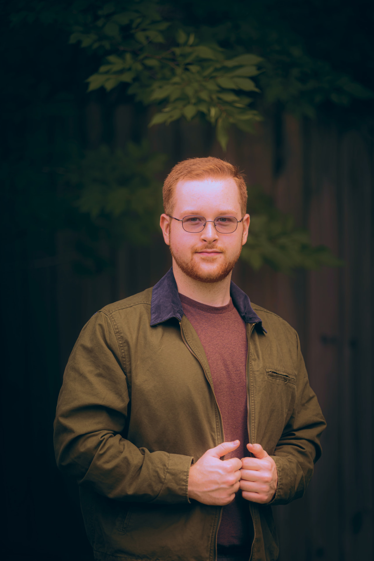 Silas Moore wearing glasses and a green jacket outdoors
